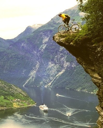 Mountain biker at Flydalsjuvet above Geiranger Fjord, Norway